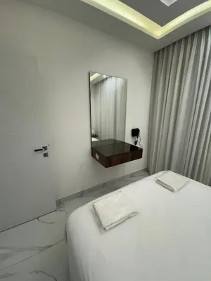 a bedroom with a white bed and a mirror at Boulevard Comfort Haven, apt with stunning veiw in Amman