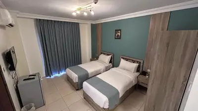a hotel room with two beds and a window at Mariam Economy Hotel in Aqaba
