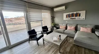 a living room with a couch and a table at An Overlooking Rooftop in Amman in Amman