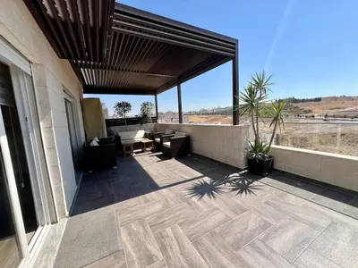 a covered patio with a view of the desert at An Overlooking Rooftop in Amman in Amman