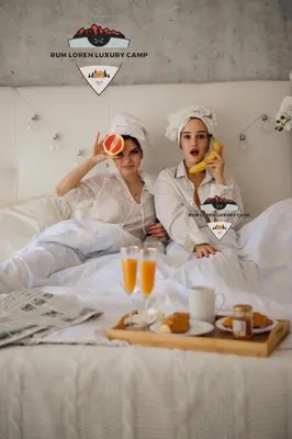 two people sitting in bed with a tray of food at RUM LOREN lUXURY CAMP in Wadi Rum