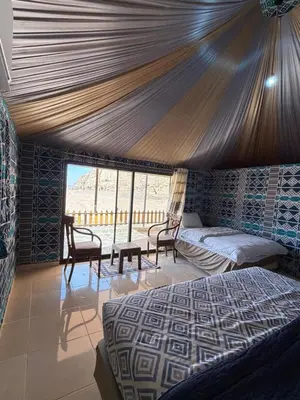 a bedroom with a bed and chairs in a room at Dune Horizon Camp in Wadi Rum