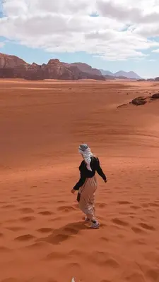 a person walking through the desert at Dune Horizon Camp in Wadi Rum