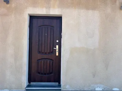 a wooden door in the side of a building at Ash Shawbak Apartment in Umm Şawwānah