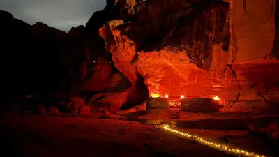 a cave with lights in the desert at night at Magic Cave Night Tours in Wadi Rum
