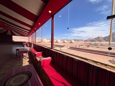 a balcony with red benches and a view of the desert at Wadi Rum Desert Wonders Camp in Disah