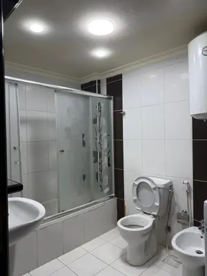 a bathroom with a shower and a toilet and a sink at Deir Ghbar apartment 116 in Amman