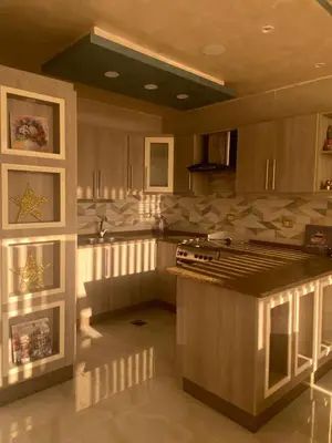 a kitchen with wooden cabinets and a counter top at studio apartment for rent in Amman