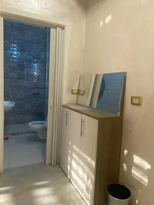 a bathroom with a toilet and a sink and a mirror at studio apartment for rent in Amman