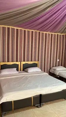 a room with two beds in a tent at Golden Camp in Wadi Rum