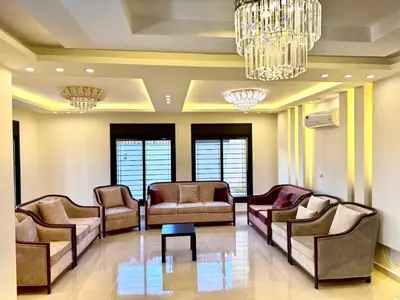 a waiting room with couches and chairs and a chandelier at Bright & Comfortable Villa in Abu Nuseir in Al Jafr