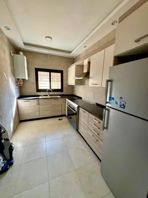 a small kitchen with a refrigerator and a window at Bright & Comfortable Villa in Abu Nuseir in Al Jafr