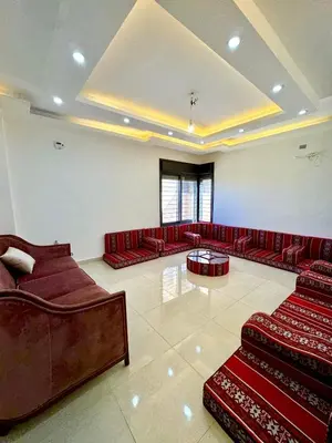 a large room with red leather couches and a table at Bright & Comfortable Villa in Abu Nuseir in Al Jafr