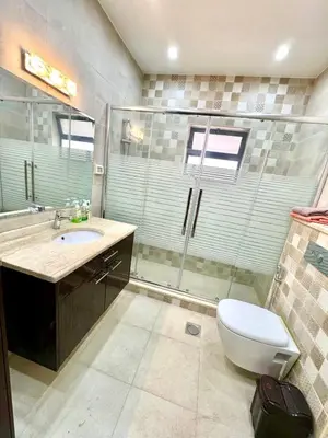 a bathroom with a toilet and a sink and a shower at Bright & Comfortable Villa in Abu Nuseir in Al Jafr