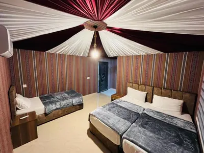 a bedroom with two beds and a ceiling at RUM FIRAS lUXURY CAMP in Wadi Rum