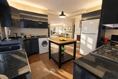 a kitchen with a table in the middle of a kitchen at Abdoun Grand Family Apartment in Amman