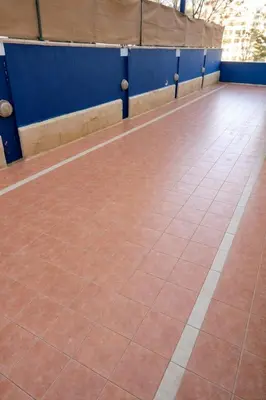 a basketball court with a red floor and blue walls at Abdoun Grand Family Apartment in Amman