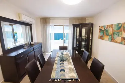 a dining room with a long table and chairs at Abdoun Grand Family Apartment in Amman