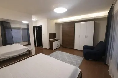 a bedroom with a bed and a couch and a chair at Abdoun Grand Family Apartment in Amman