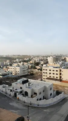a large white building in front of a city at LaPerla Rooftop family in Amman