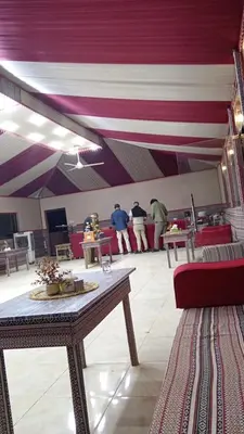 a room with a table and people standing in the background at DESERT PULSE lUXURY CAMP in Wadi Rum