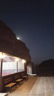 a group of benches sitting on a deck at night at DESERT PULSE lUXURY CAMP in Wadi Rum