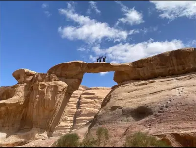 three people standing on top of a rock formation at Essam camb in Disah