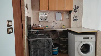 a small kitchen with a sink and a washing machine at Stone house in Amman