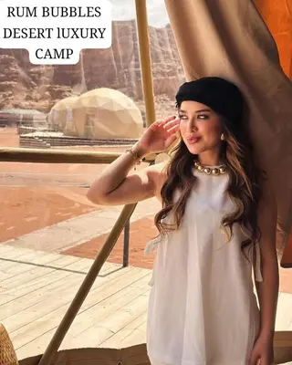 a woman is standing next to a tent at RUM BUBBLES DESERT lUXURY CAMP in Wadi Rum