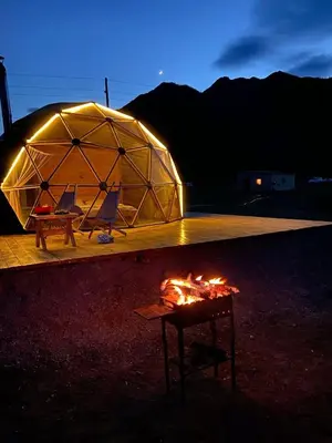a tent with two chairs and a table with a fire at rum magic luxury camp in Wadi Rum