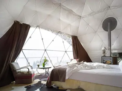 a bedroom with a tent with a large window at rum magic luxury camp in Wadi Rum