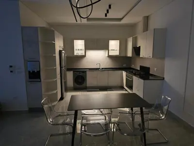 a kitchen with a table and chairs in it at Two-bedroom family friendly modern apartment in Amman