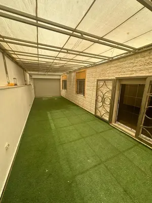 an empty room with a green floor in a building at Irbid in Nāţifah