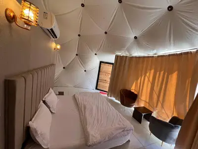 a bedroom with a bed in a tent at Golden Dunes Camp Wadi Rum in Wadi Rum