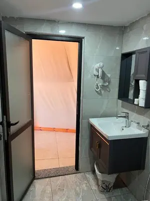 a bathroom with a sink and a mirror and a shower at Golden Dunes Camp Wadi Rum in Wadi Rum