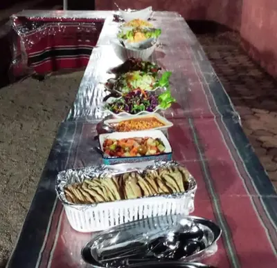 a long table with many plates of food on it at Enad wadirum camp in Wadi Rum