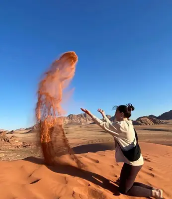 a woman standing in the desert with a volcano at Enad wadirum camp in Wadi Rum