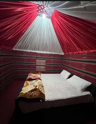 a room with a bed with a red ceiling at Enad wadirum camp in Wadi Rum