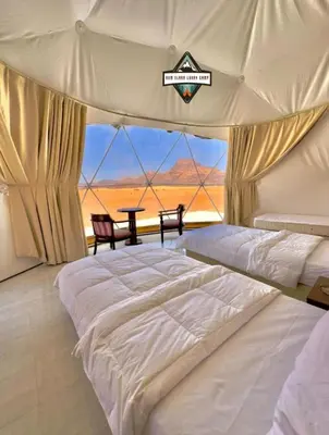 a bedroom with a bed and a table in a tent at RUM ELARA lUXRY CAMP in Wadi Rum