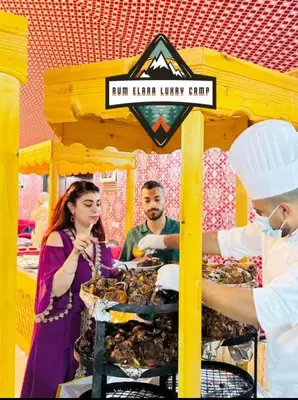 a group of people standing around a food stand at RUM ELARA lUXRY CAMP in Wadi Rum