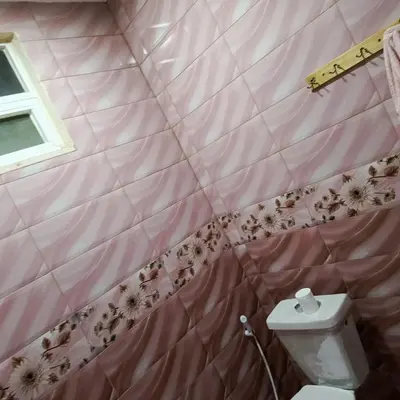 a pink tiled bathroom with a toilet and a window at المناره هاوس in Wadi Musa
