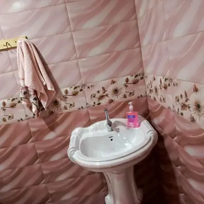 a bathroom with a sink and a pink tiled wall at المناره هاوس in Wadi Musa
