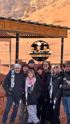 a group of people standing in front of a sign at WADi RUM ROTANA BUBBLE lUXURY CAMP in Wadi Rum
