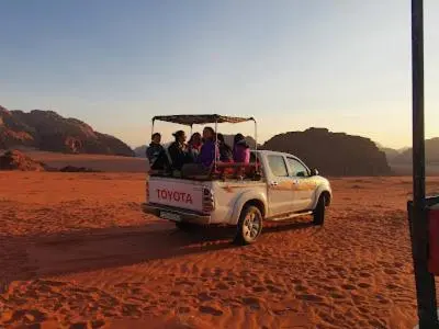 a group of people riding in the back of a truck at Bedouin Whispers Camp wadirum in Wadi Rum