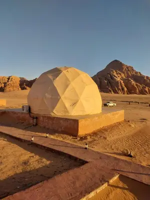 a dome in the desert with a mountain in the background at Essam in Wadi Rum