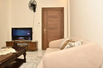 a living room with a couch and a tv at شقة مفروشة مع ساحة خارجية قرب دوار اليوسفي in Irbid