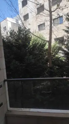 a view of a tree in front of a building at Chic 2-Bedroom - Fully Furnished in Amman