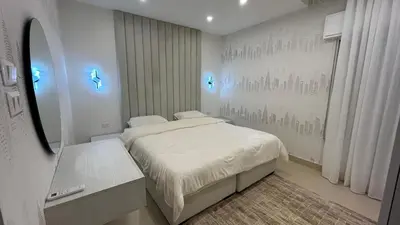 a small bedroom with a bed and a mirror at Modern Apartment in Um Uthaina Amman in Amman