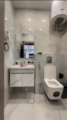 a white bathroom with a toilet and a sink at Modern Apartment in Um Uthaina Amman in Amman