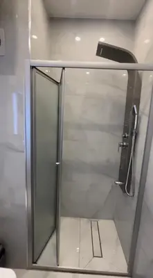 a shower with a glass door in a bathroom at Modern Apartment in Um Uthaina Amman in Amman